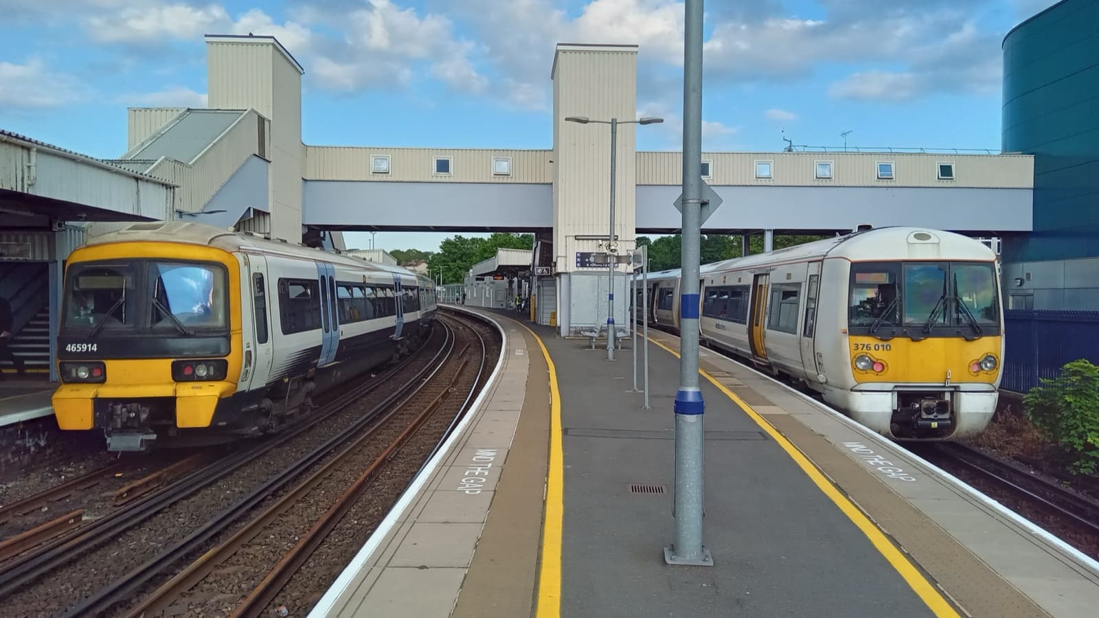 Two trains at the platforms of Dartford station under a footbridge