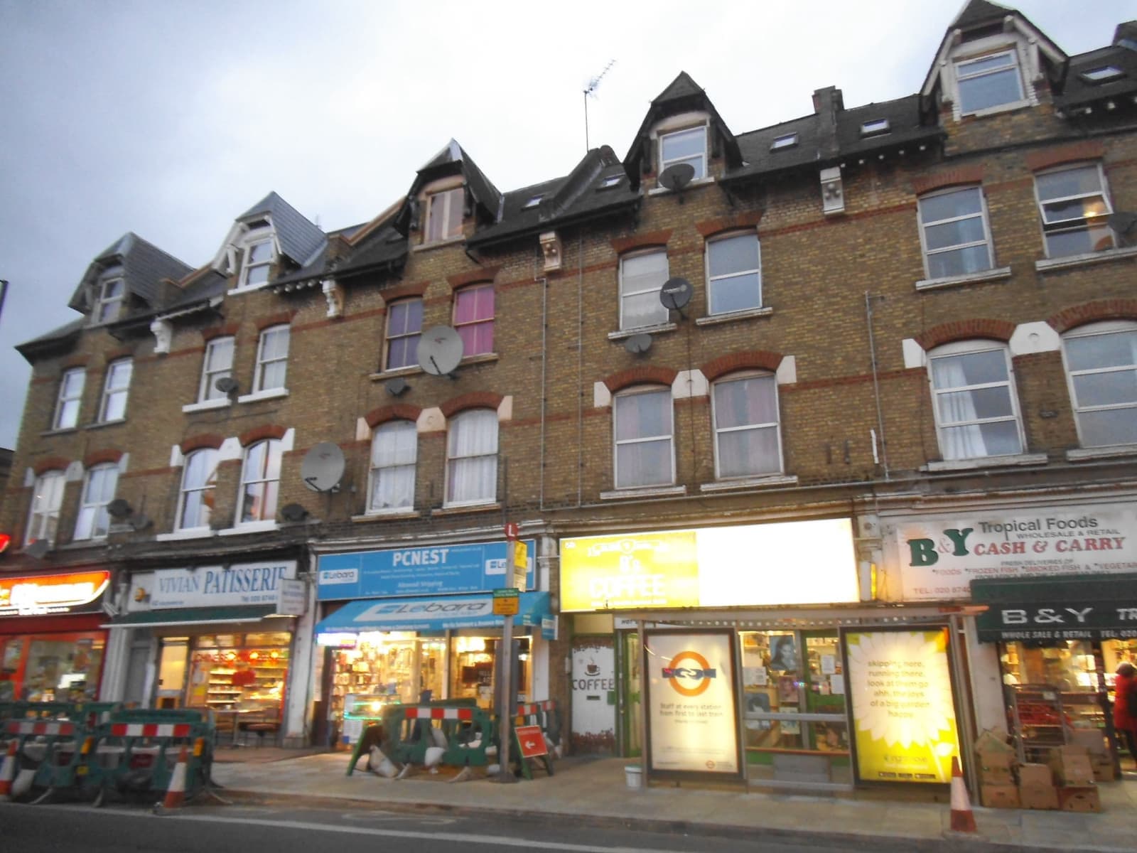 A terrace of brick shops with flats above on Goldhawk Road
