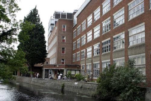 College buildings beside a stream with trees