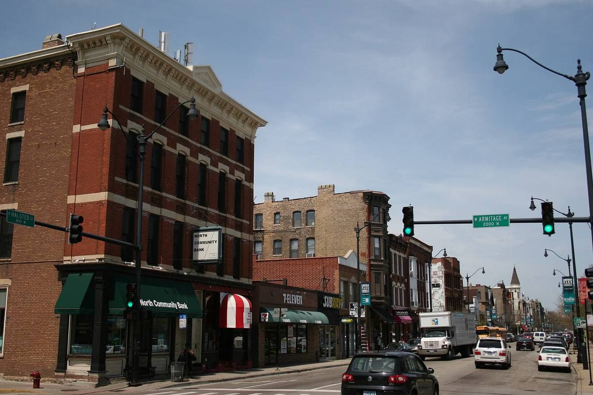 A brick corner block on a Chicago avenue with shops and traffic lights