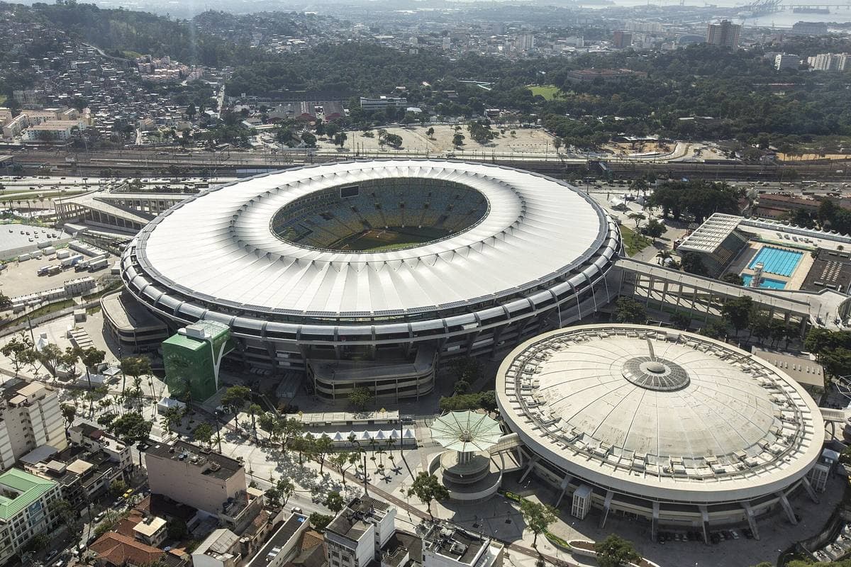 An aerial view of a round white-roofed stadium in a city