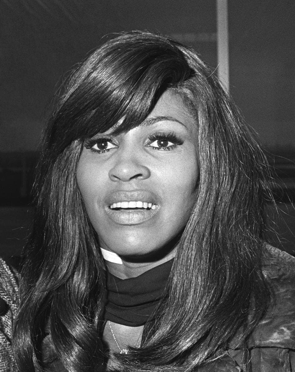Tina Turner in close-up with long dark hair, in black and white