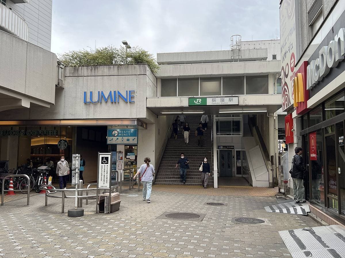A station entrance with a Lumine sign and steps under a grey sky