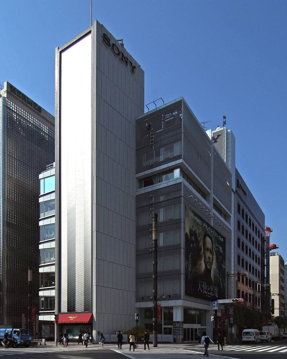 A tall narrow grey Sony tower on a Ginza corner under blue sky