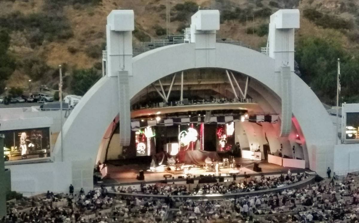 The white arched shell of the Hollywood Bowl lit at dusk, crowds in the seats