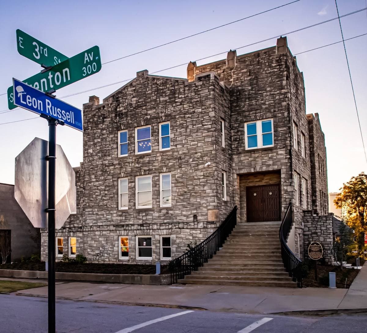 A grey stone former church with a tall stair and arched windows, now a studio and museum