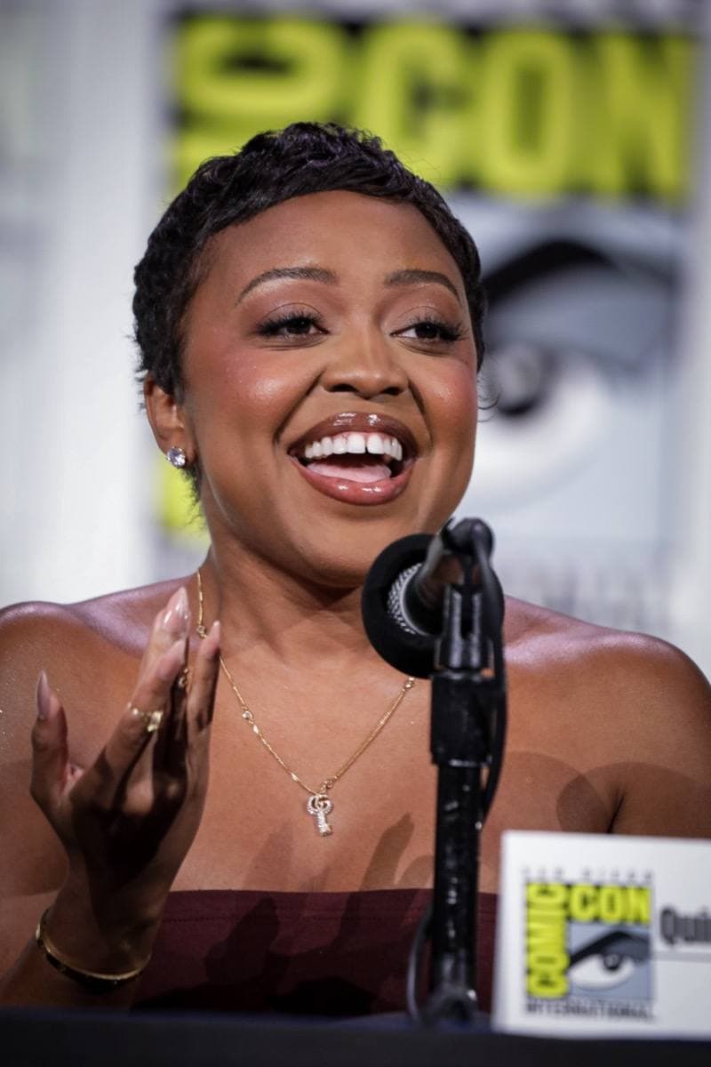 Quinta Brunson smiling at a convention panel