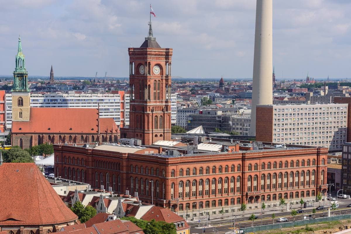 A red-brick town hall with a tall clock tower under a blue sky