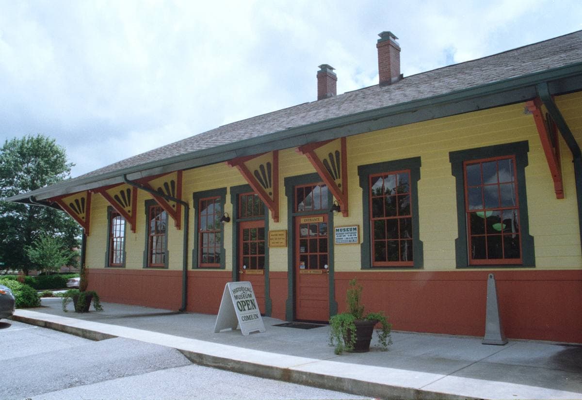 A brick railway depot building with a canopy