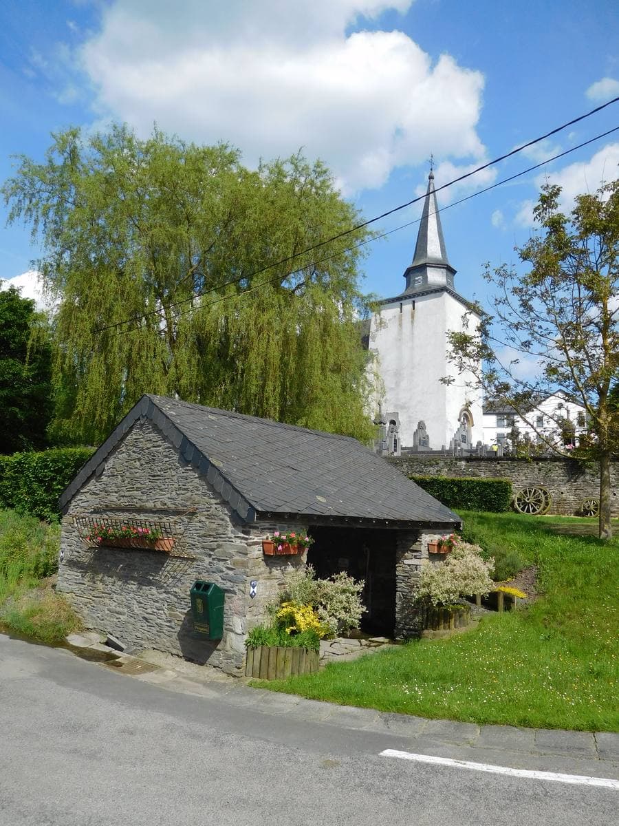 A small stone church with a slate spire