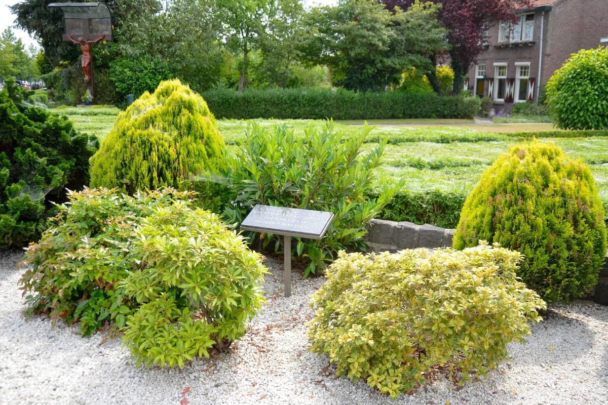 A small memorial garden with a plaque by the bridge