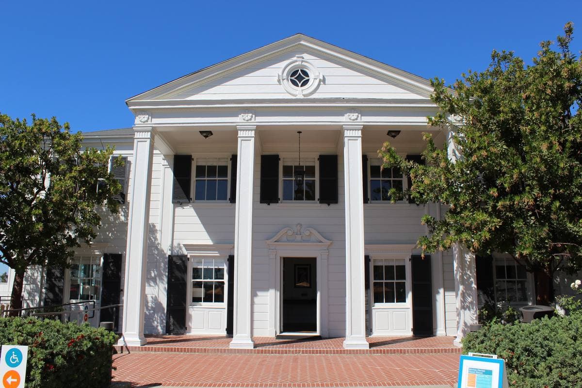 White beach house entrance with low modern buildings and blue sky on the Santa Monica shore