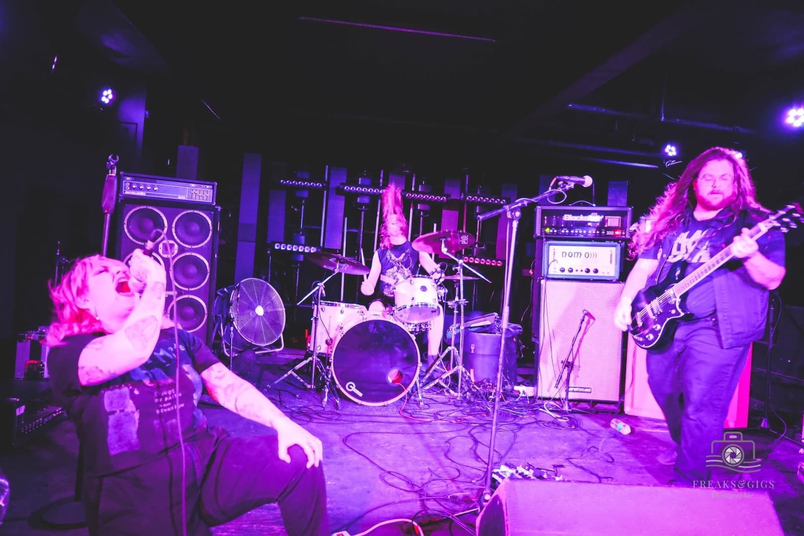 A band playing under violet stage light at Electrowerkz