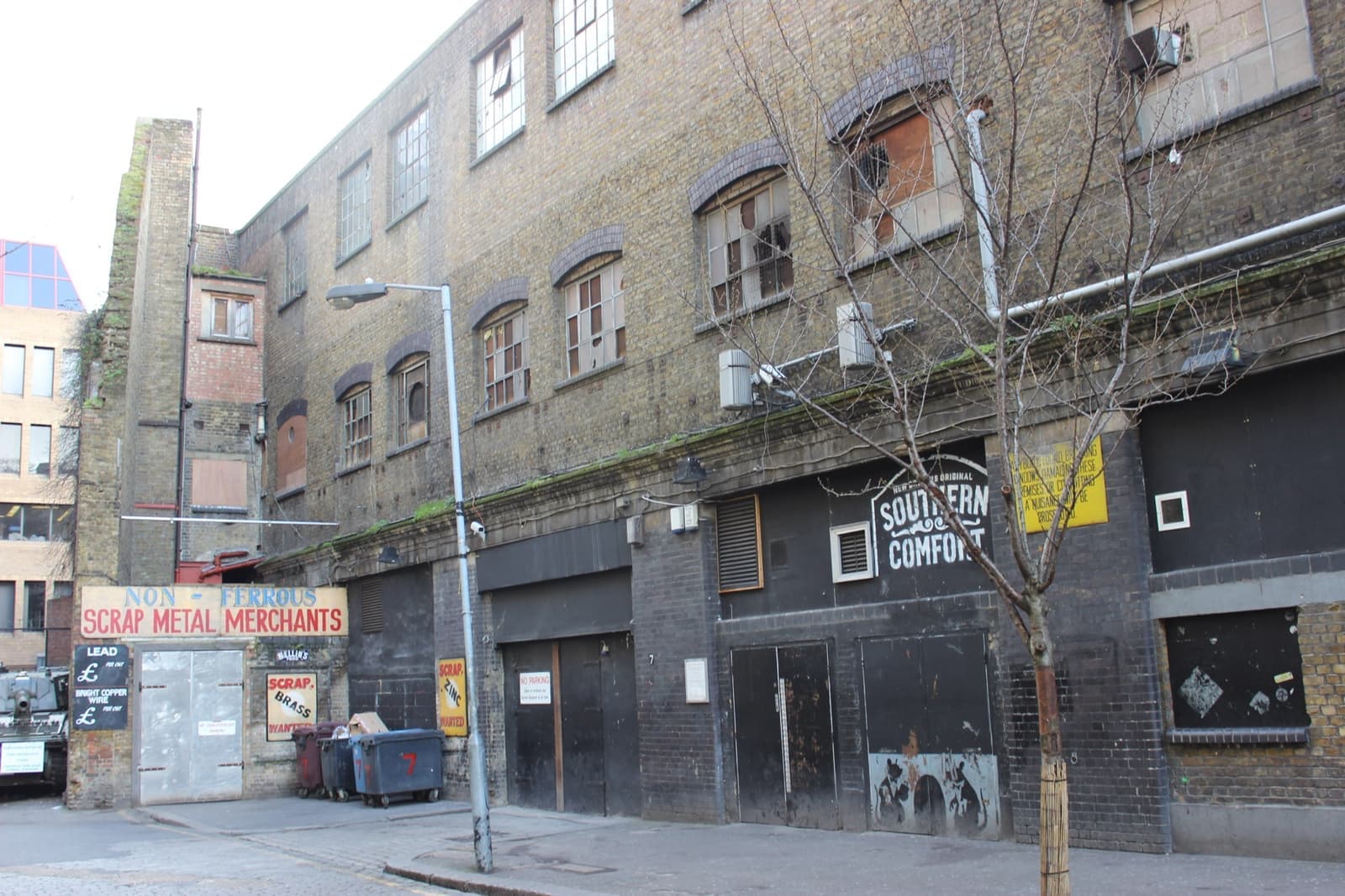 A brick warehouse on Torrens Street with a corrugated entrance and painted signs