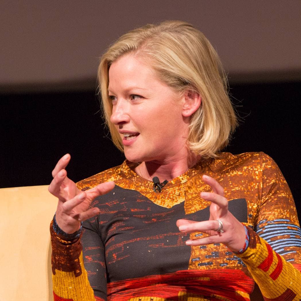 Gretchen Mol with short blonde hair, gesturing as she talks