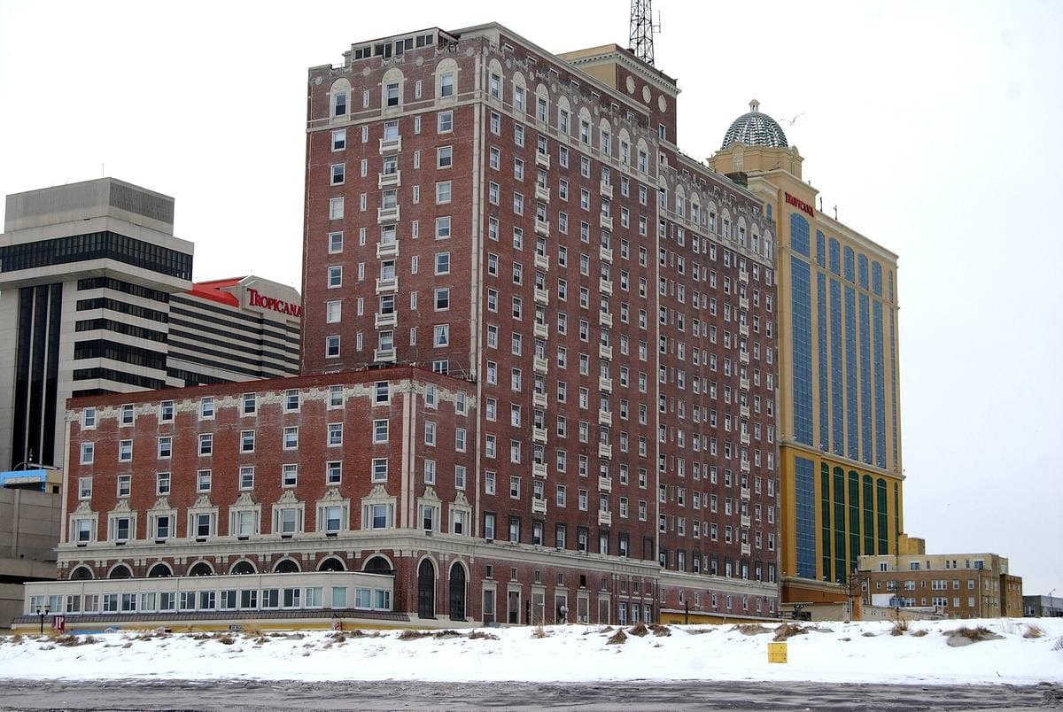 A tall red-brick building with a copper-roofed tower above the Boardwalk in snow