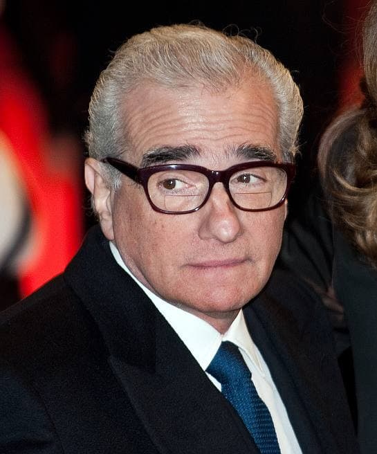Martin Scorsese in heavy black glasses and a dark suit