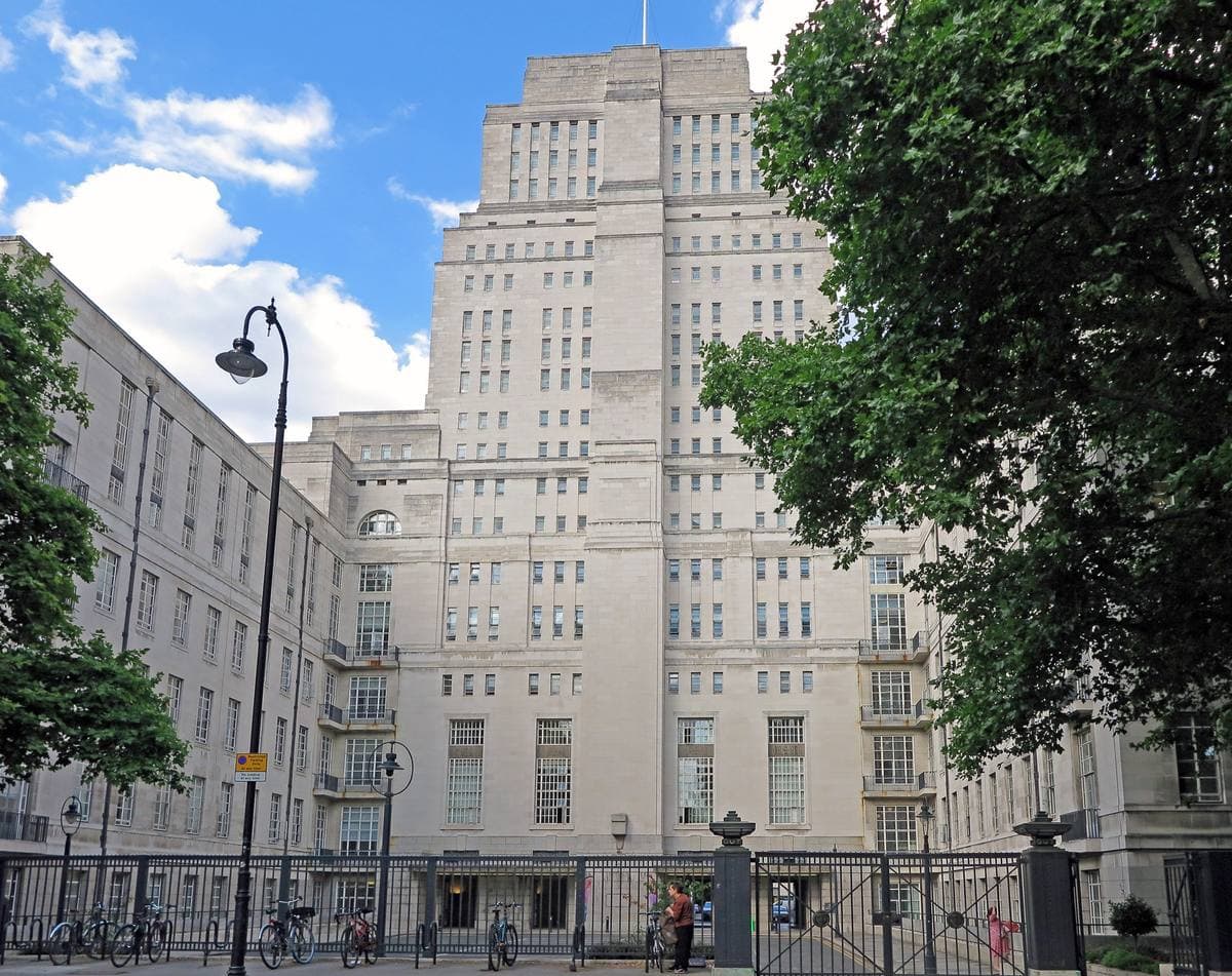 The pale stone tower of Senate House behind trees on Malet Street