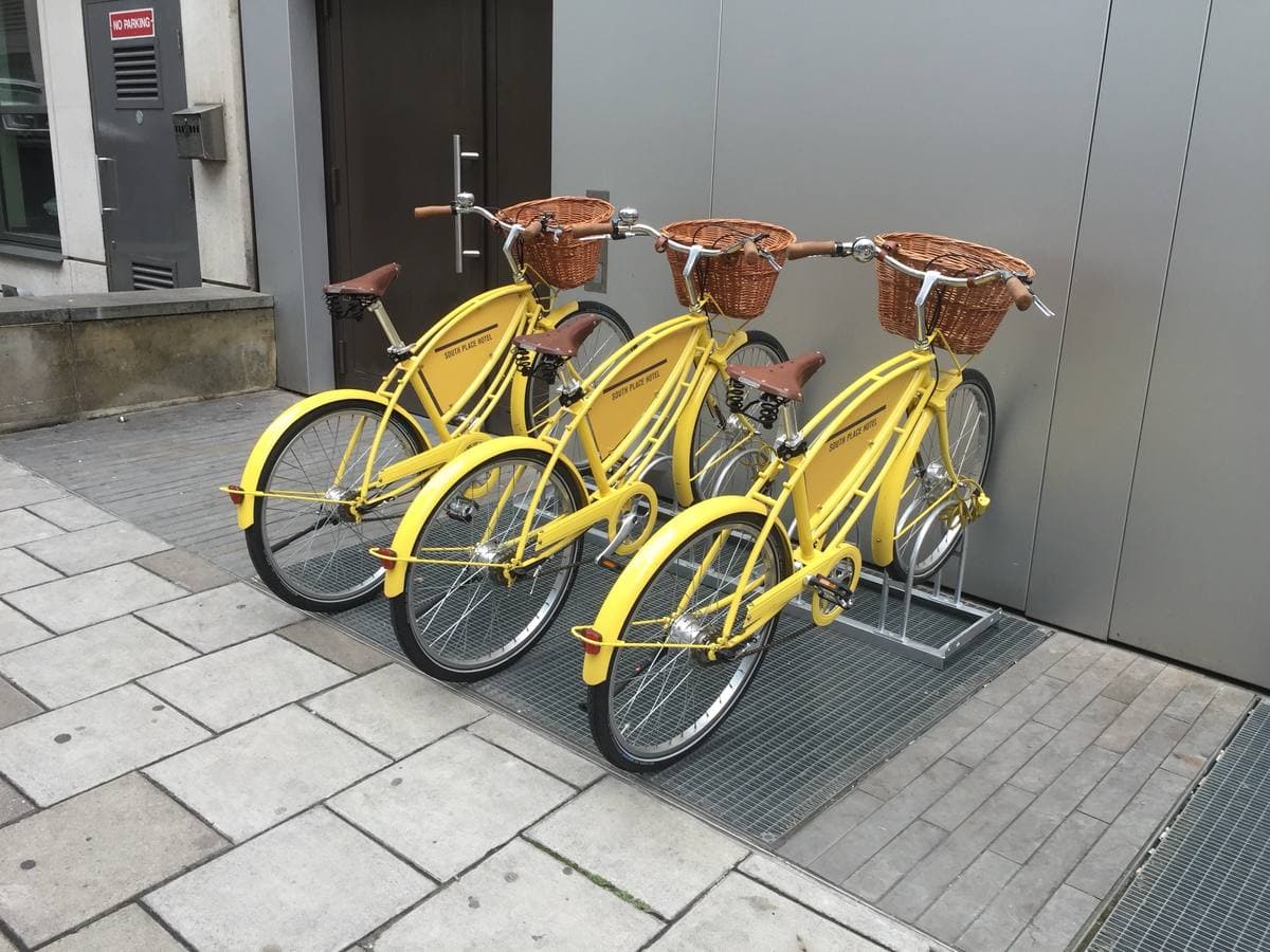 A modern hotel front with a row of hire bikes