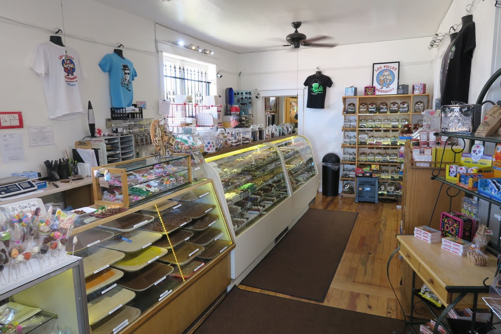Glass candy cases, shelves and T-shirts inside a small sweet shop