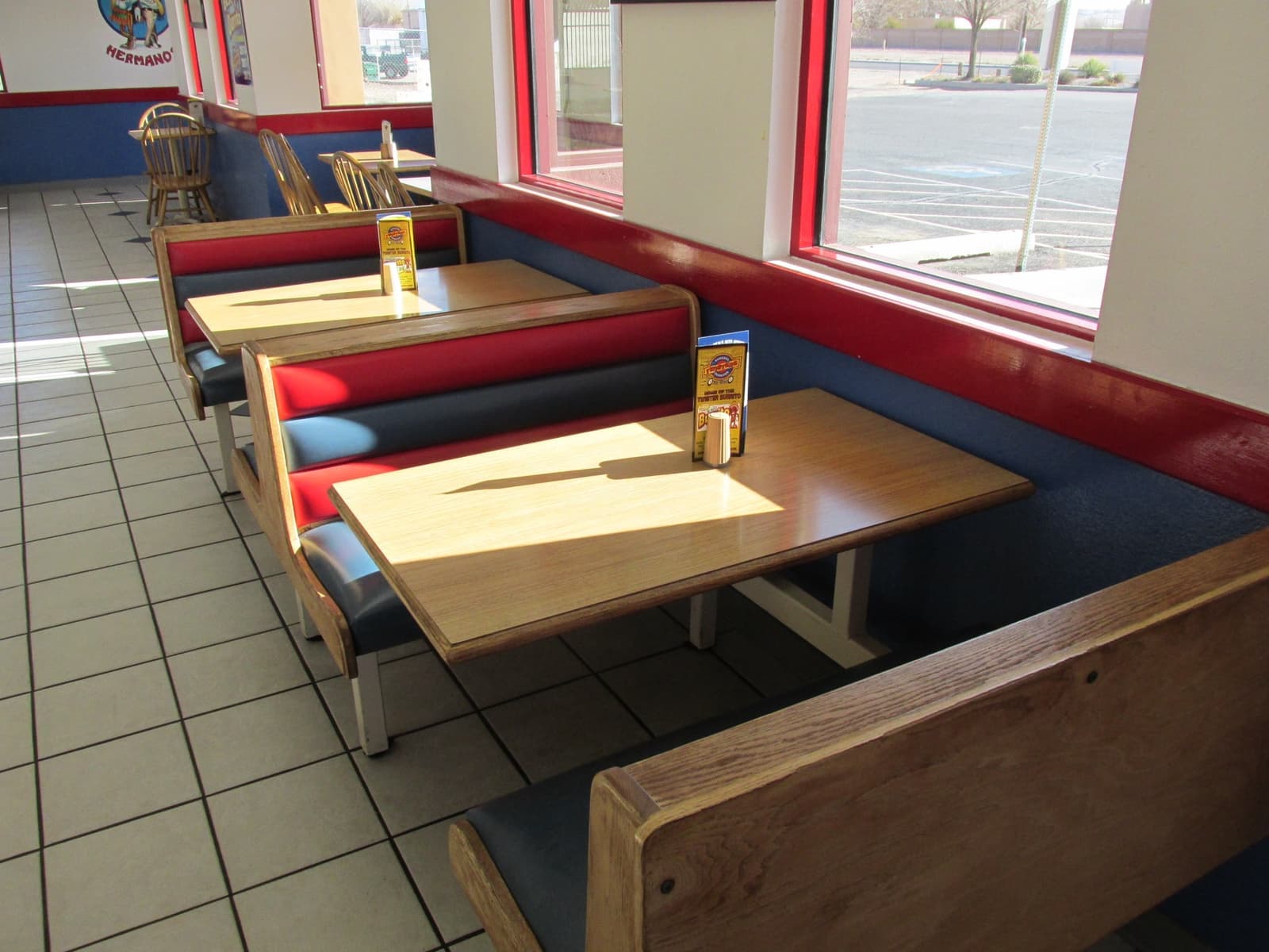 Booths and tables under red pendant lamps in a fast-food dining room