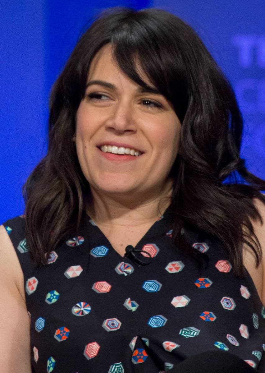 Abbi Jacobson smiling, long dark hair, at an indoor event
