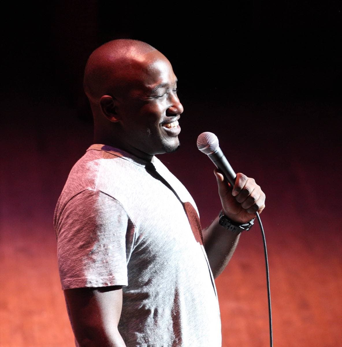 Hannibal Buress on a stage holding a microphone