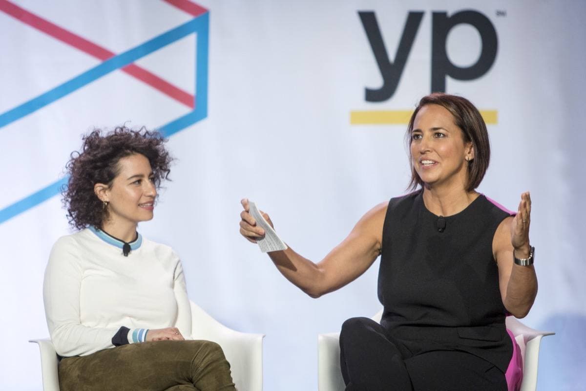 Ilana Glazer with curly dark hair, talking on stage