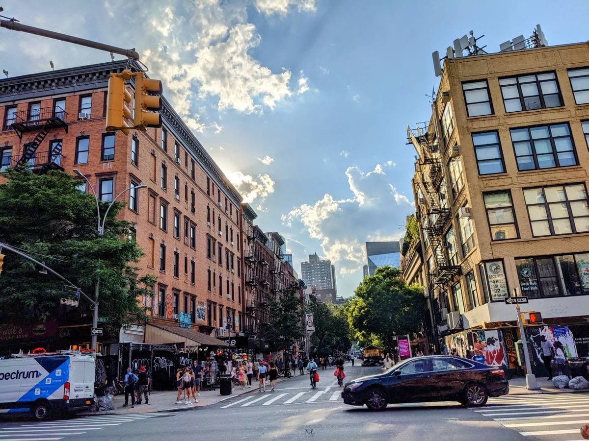 A busy East Village street of low brick buildings and shopfronts