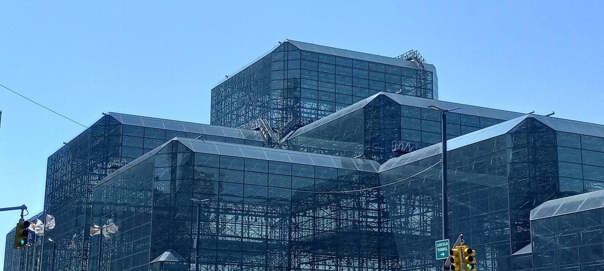 A huge glass-walled convention hall seen from the street