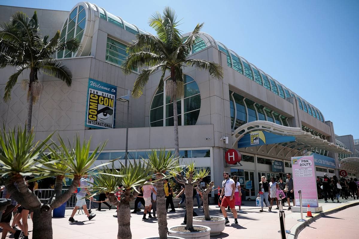 Crowds outside the long glass front of a convention center