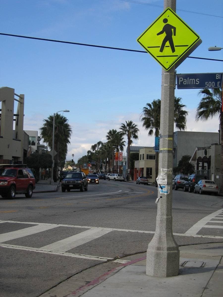 A crosswalk on a low-rise shopping street in Venice