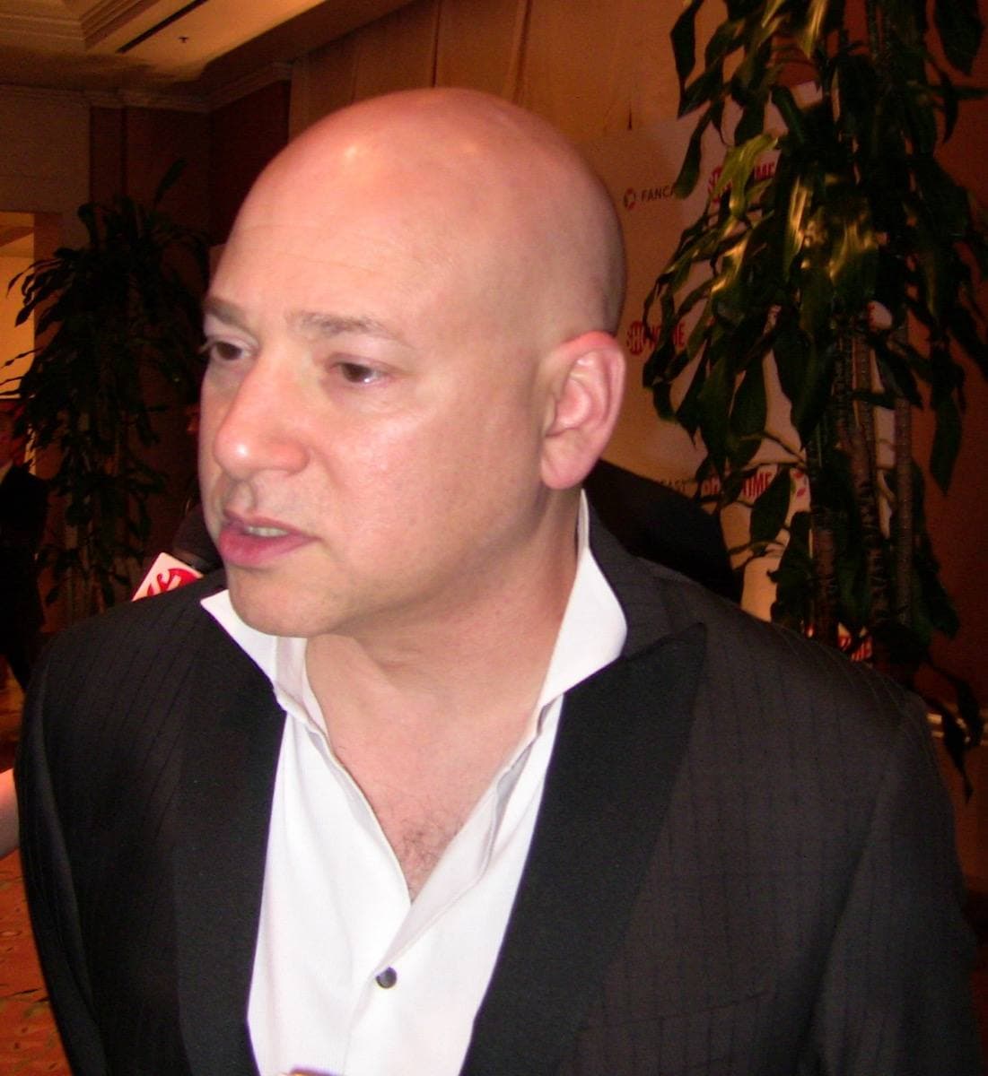 Evan Handler in a suit and tie, smiling