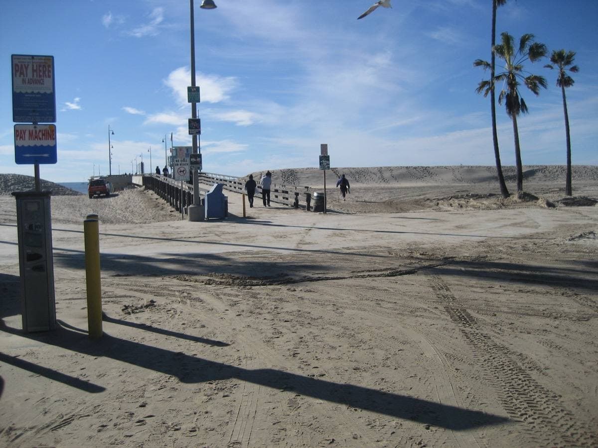 A long concrete pier running out over the sea from the beach