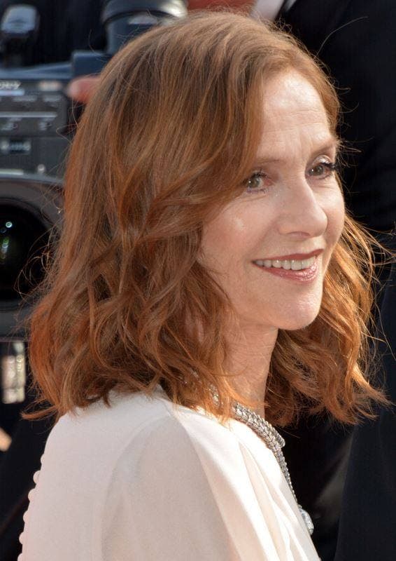 Isabelle Huppert smiling, auburn hair to her shoulders