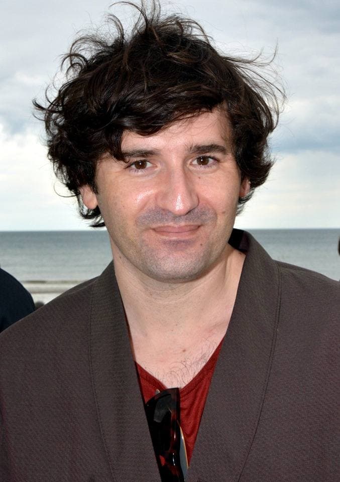 Nicolas Maury, curly dark hair, by the sea at Cabourg