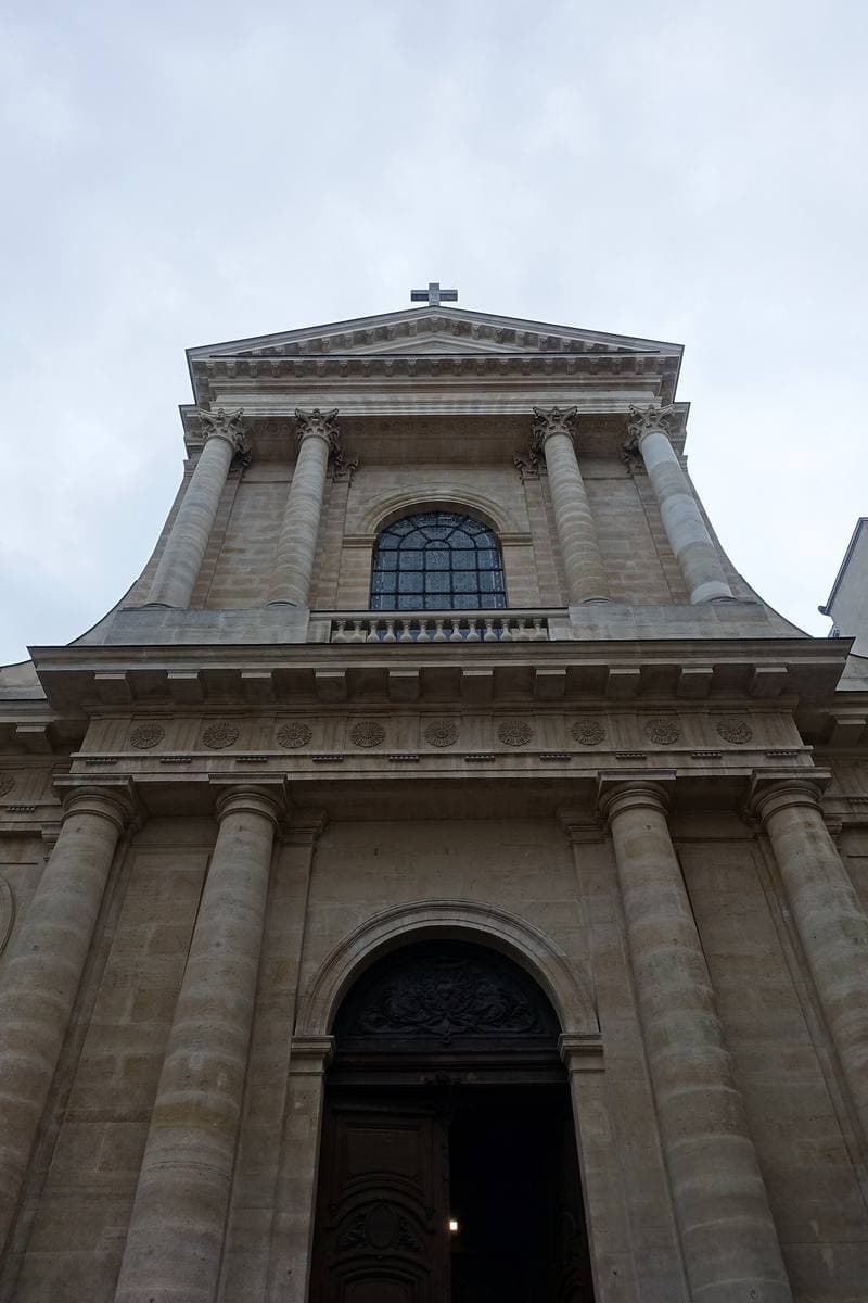 A classical church front with columns and a pediment, seen from below