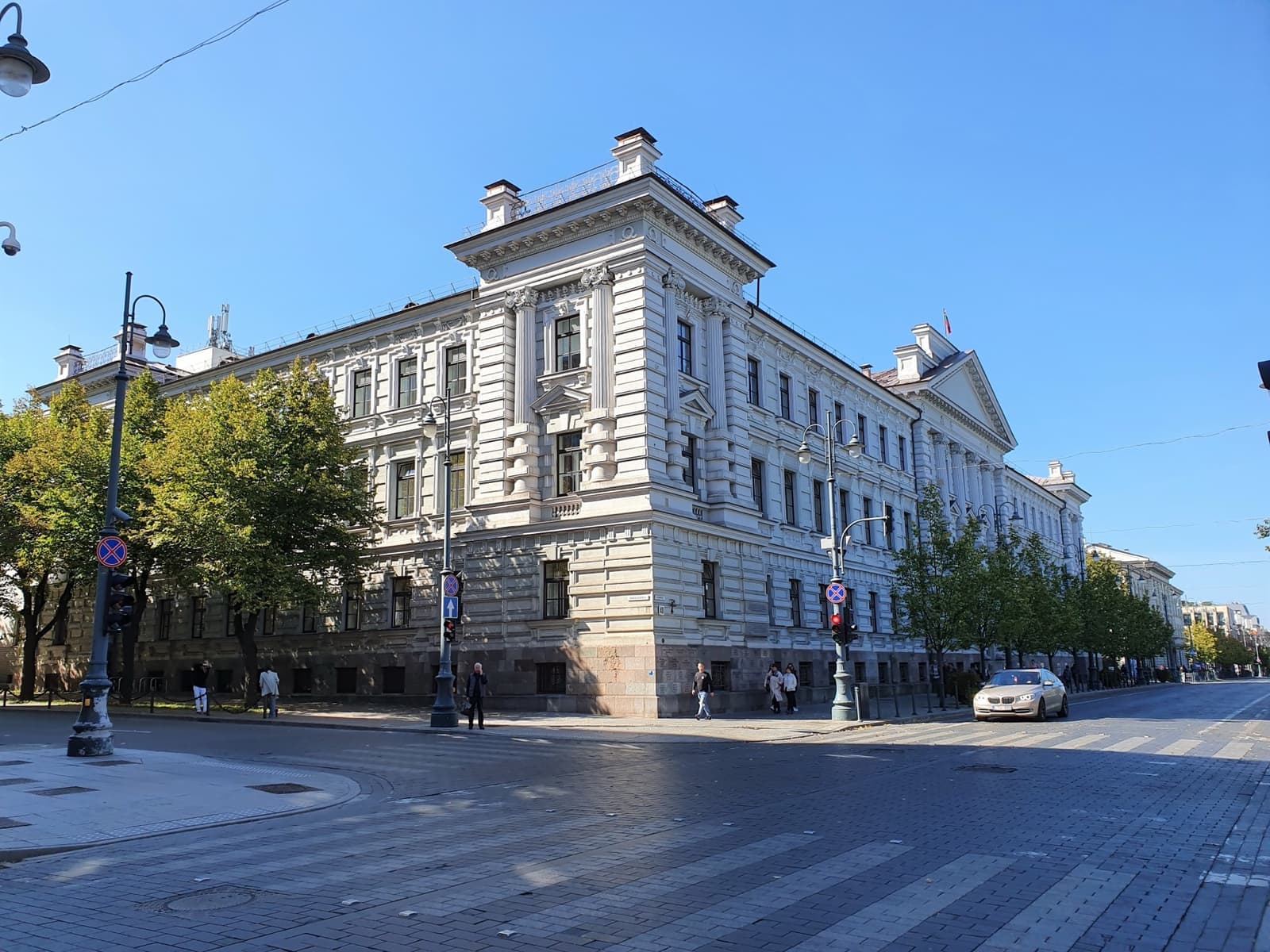 A large pale neo-classical building on a street corner