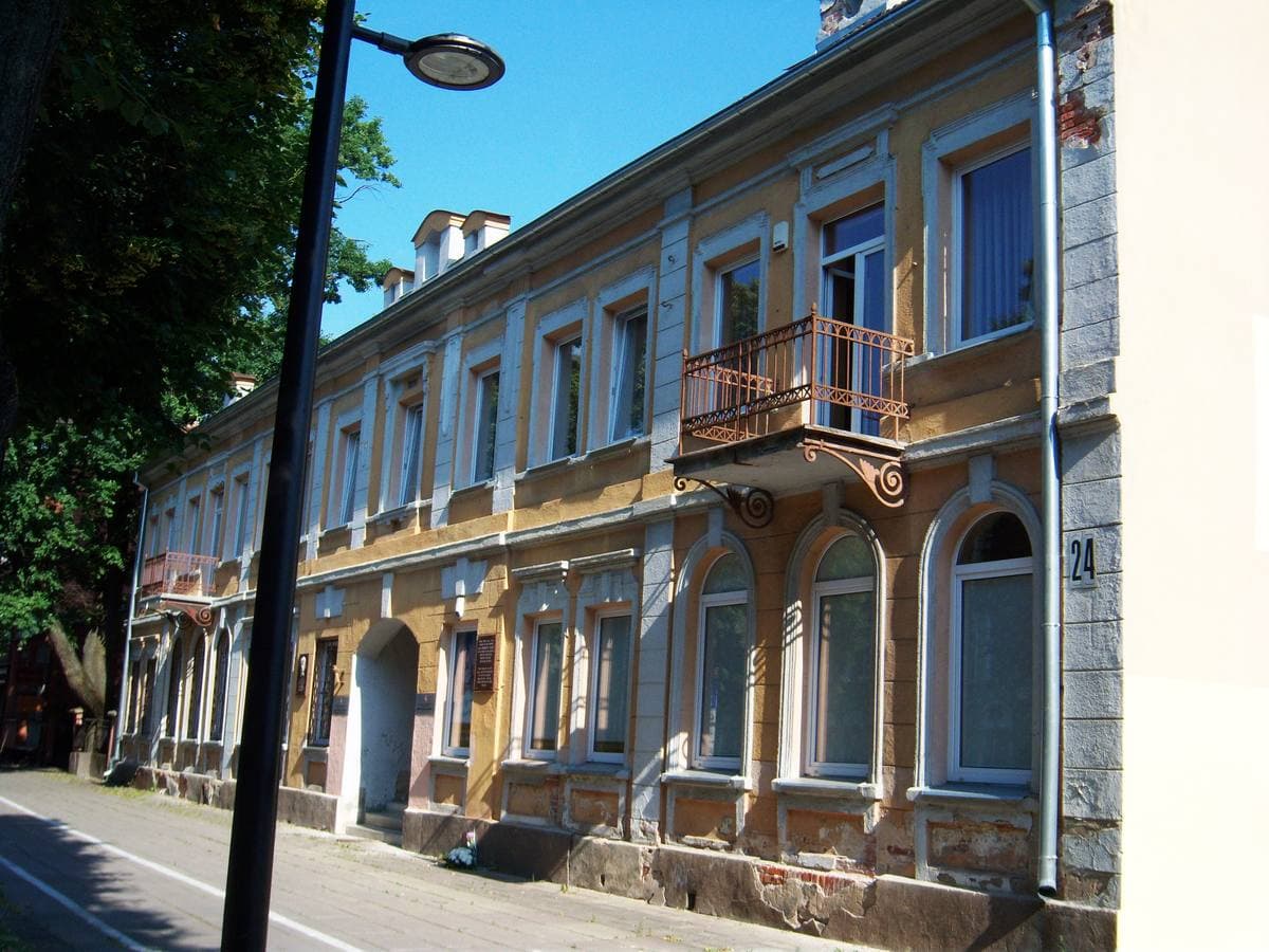 A yellow-fronted building with gables and a balcony on Laisvės alėja