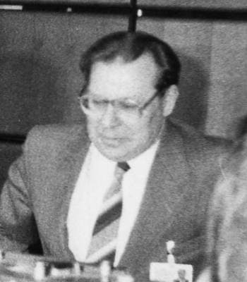 Valery Legasov in glasses at a conference table, black and white