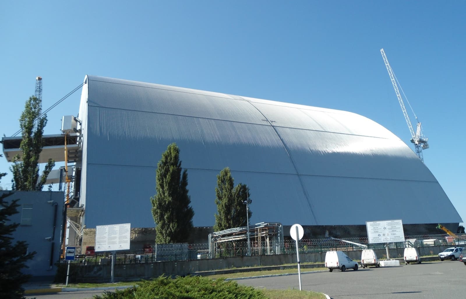 A huge steel arch over the Chernobyl reactor site under a blue sky