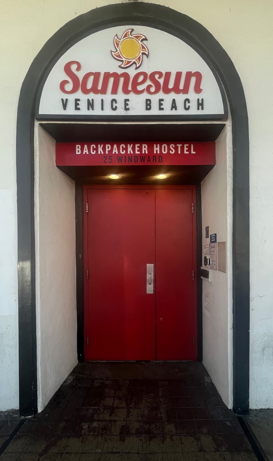 The red doors of the Samesun hostel under an arch on Windward Avenue, Venice