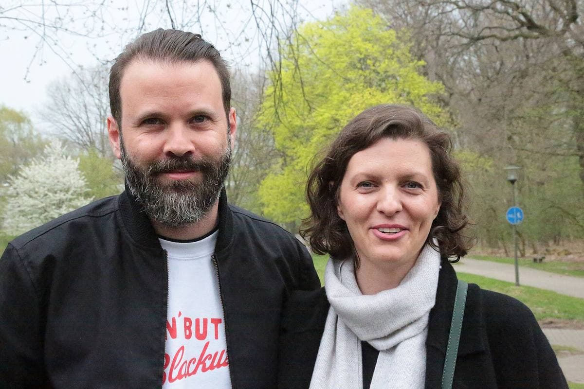 Jantje Friese and Baran bo Odar standing together outdoors under spring trees
