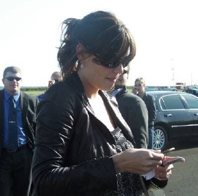 Katie Holmes smiling while signing autographs