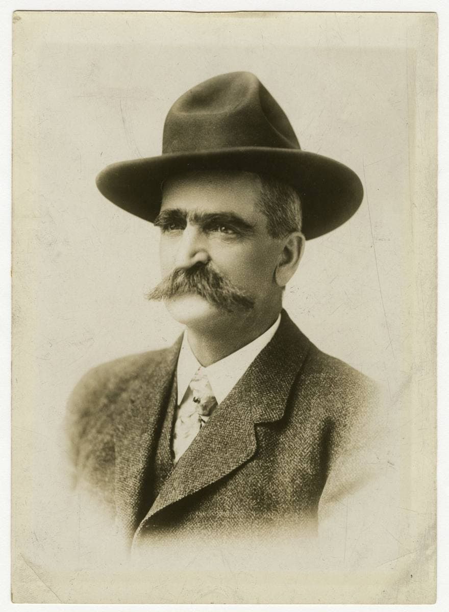 Seth Bullock in a dark hat and suit, with a large moustache