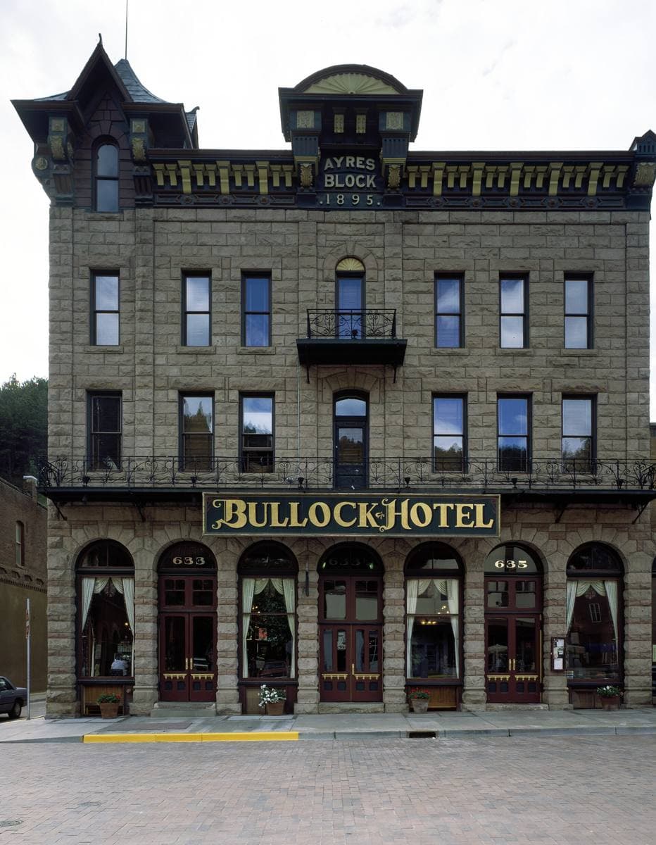 A three-storey stone hotel with a corner turret and Bullock Hotel lettered across the front