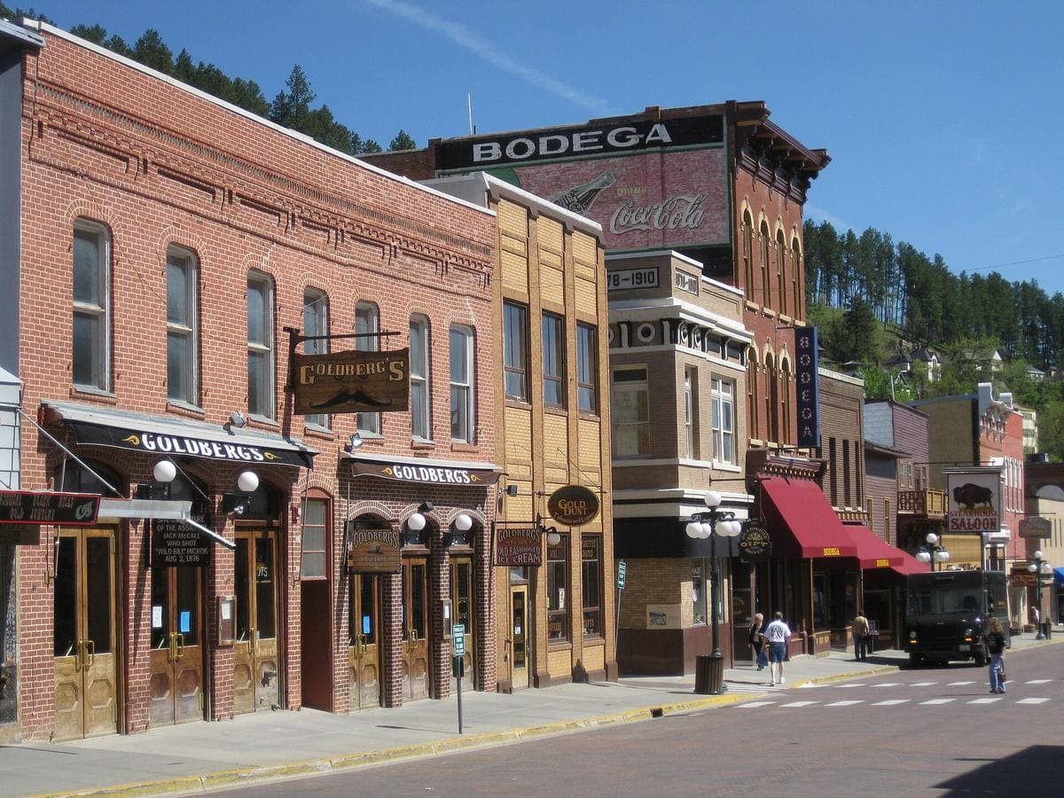 Brick shopfronts and casino signs along Main Street under a blue sky