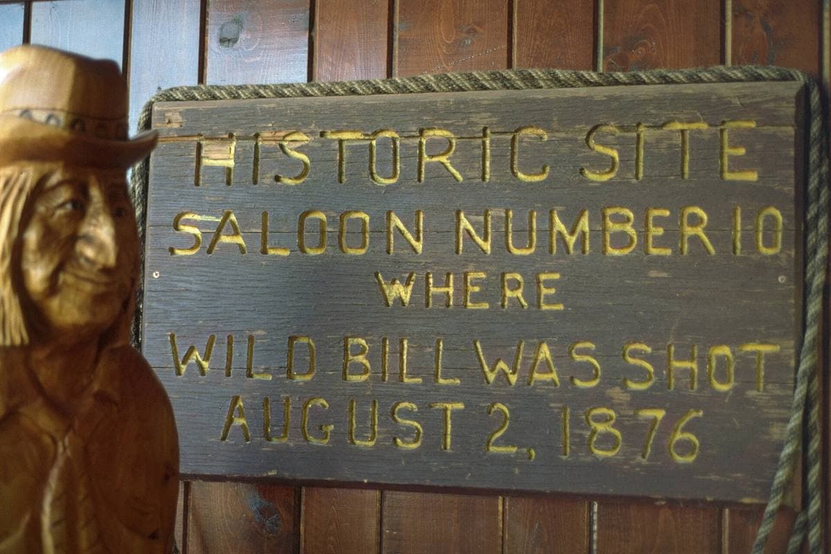 A carved wooden sign reading Historic site, Saloon Number 10, where Wild Bill was shot, August 2, 1876