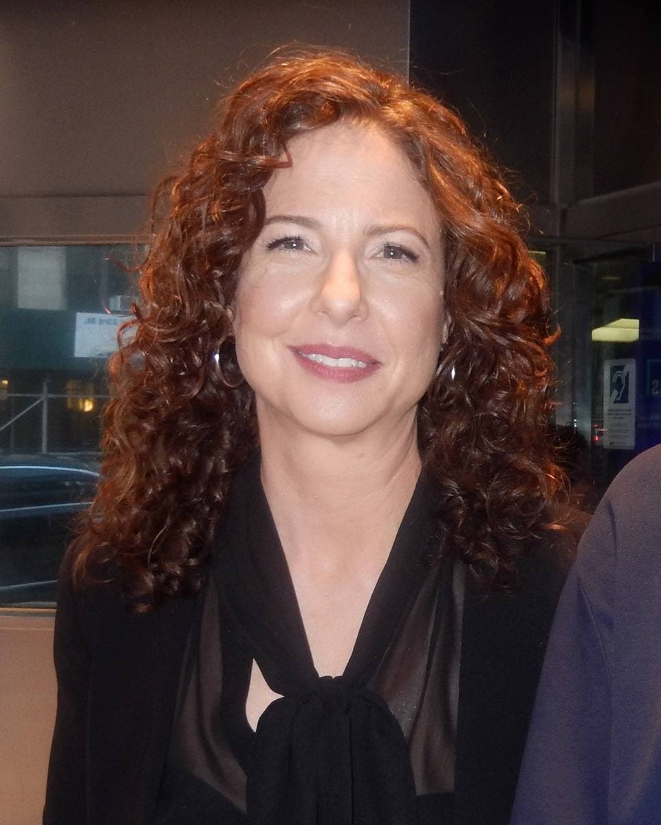 Robin Weigert with long red curls, smiling