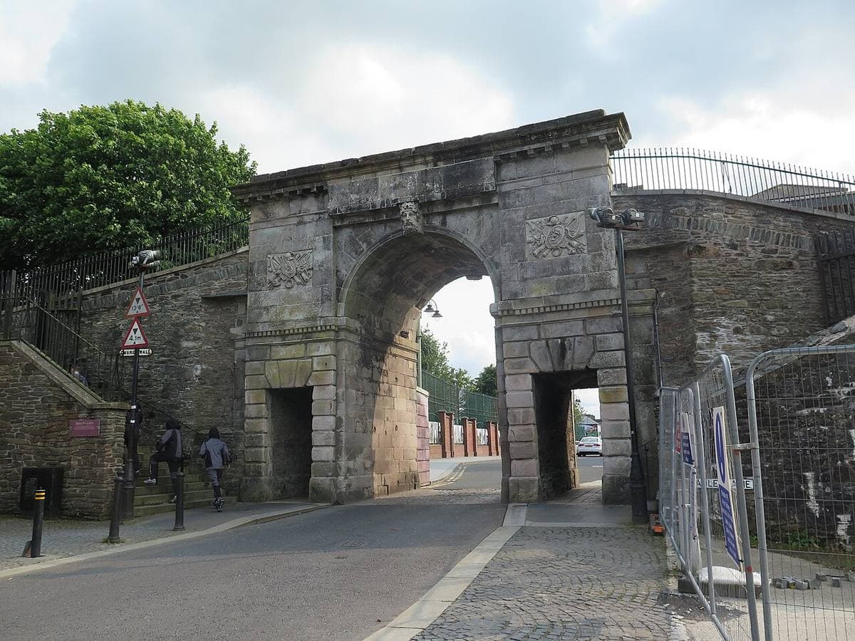 A stone triumphal-arch gateway with a road running through it
